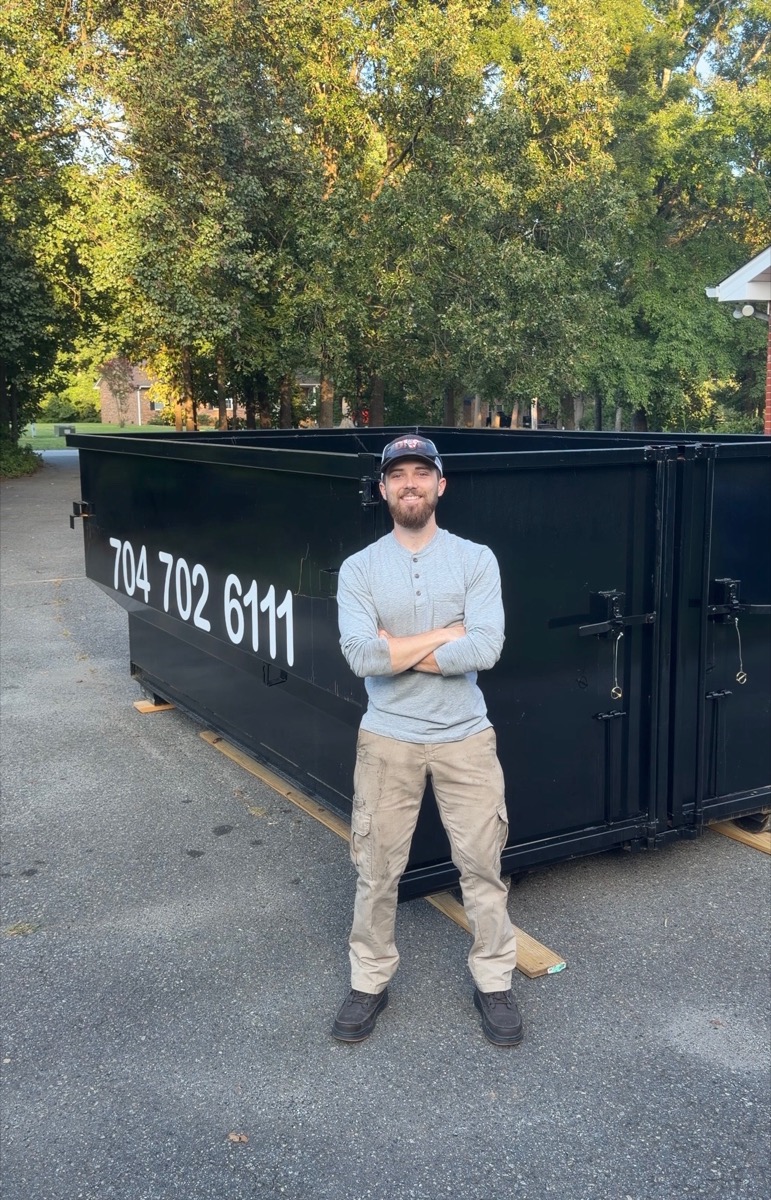 Mike, owner of Yak Dumpsters, in front of a 15-yard dumpster delivered to a driveway on protective boards